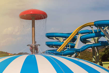 Children playing in waterpark on sky background. View of water parkの写真素材