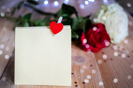 Beautiful white and red roses on wooden table background with mockup.の写真素材