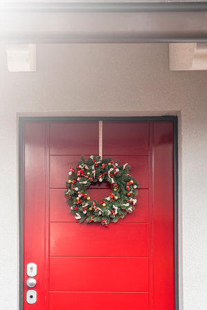 Christmas wreath hanging on a red wooden door.の写真素材