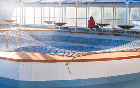A lonely man in red relaxing at the table of a cruise ship - travel and vacation conceptの写真素材