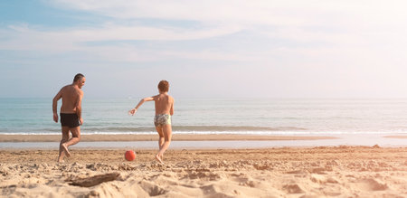 Father and son running on the beach with copy space. Playful casual family enjoyingの写真素材