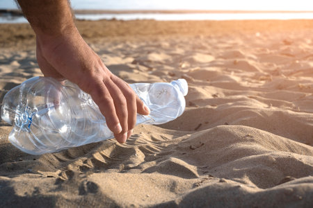 Hand picking up plastic bottle cleaning on the beach , volunteer conceptの写真素材