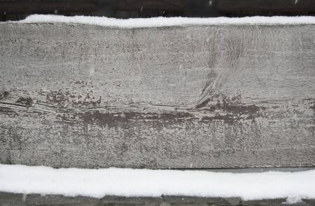 old dark wooden fence in snow. wood background with snowflakes.の写真素材