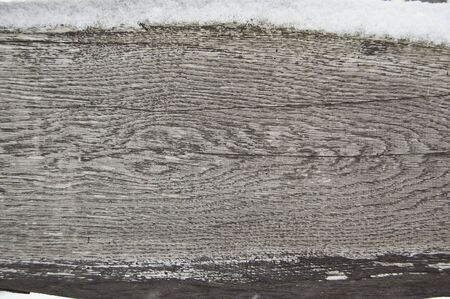old dark wooden fence in snow. wood background with snowflakes.の写真素材