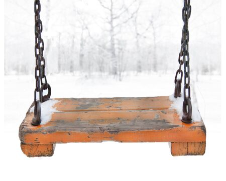 Orange wooden swing with metal chain suspension on the foregroundの写真素材
