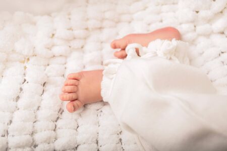 Photo of newborn baby feet on a white cover, close upの写真素材