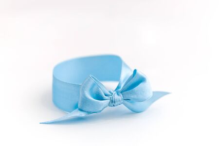 One blue bow bracelet lie on a white background. Symbol of the sexual identity of the boy, close-up.の写真素材