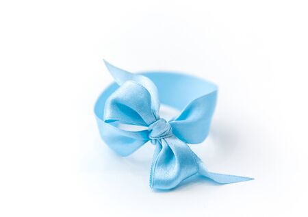 One blue bow bracelet lie on a white background. Symbol of the sexual identity of the boy, close-up.の写真素材