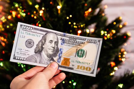 new year fir tree is decorated with 100 dollars cash, close-upの写真素材