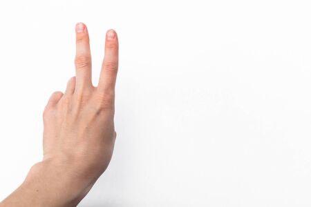 female hand on white background showing the symbol of victory or the number two or sexual insultの写真素材