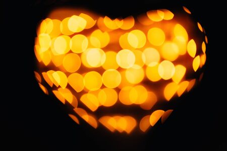 silhouette of the symbol of love - hearts against the bright orange blurred lights, valentine cardの写真素材