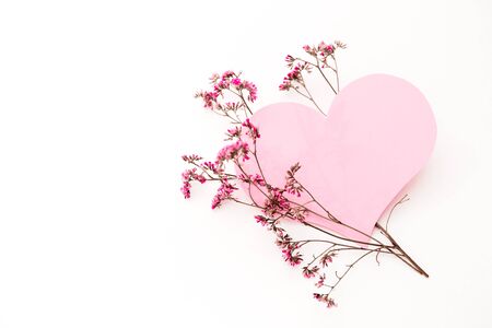 A large pink heart with a place for text decorated with small pink flowers on a white background, symbol of loveの写真素材
