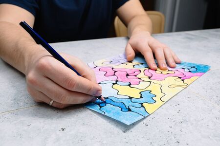 man draws an abstract imaginary picture with a pencil and decorates it with different colors, a...