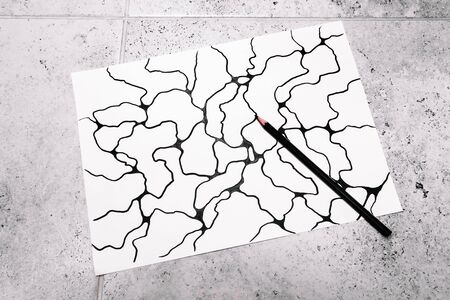 Man painted an abstract imaginary picture of curves by a black pencil in his hand. A psychological...