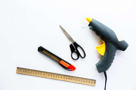 Ruler, knife, scissors and glue gun isolated on a white background. Necessary tools for creating...