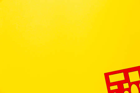 Red geometric ruler with circle, square, rectangle, triangle shapes on a yellow background and free space for text. Banner on the theme of school supplies and stationery for drawing. Sales.の写真素材