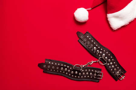 Red color banner with black leather bracers and metal rivets for shackling hands or legs and...