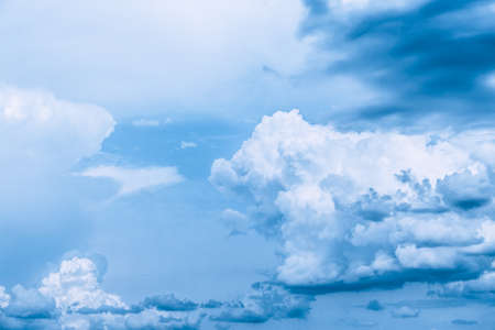 White clouds against a bright blue sky. Change from clear sunny weather to cloudy. Wallpaper for news about weather forecast. Clearing after rain. Religious appeal to the Almighty. Infinity feel.の写真素材