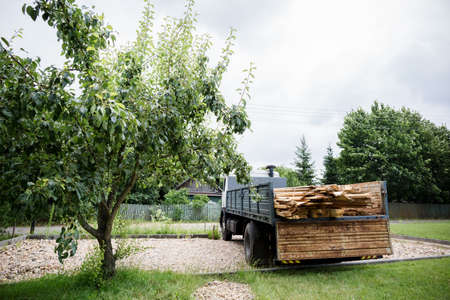 A planed board lies on board the truck. Building materials were brought to the construction site. Chopped wood for interior use. Cargo transportation of oversized items. Banner with copy space.の写真素材