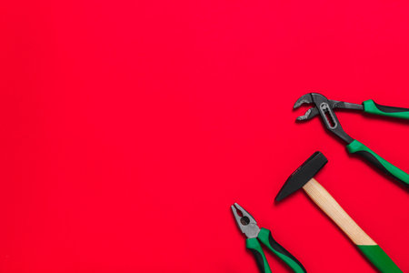 A set of quality green building tools to repair a car or a house on a red background. Do it yourself instruments. Banner for advertising construction shop with copy space. Business card.の写真素材
