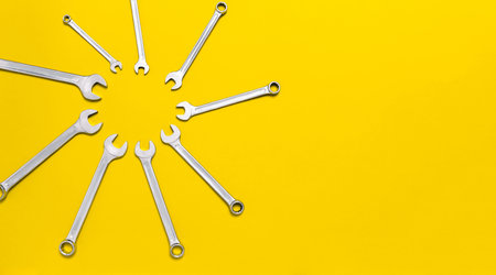 Wrenches different size in shape of sun on yellow background. Sunny banner with tools. Postcard with...