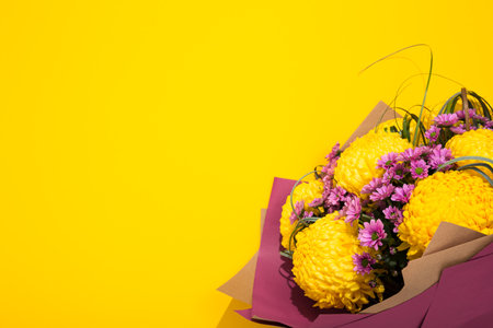 Lush and small chrysanthemums bouquet on bright yellow background with copy space, text place. Flower shop certificate. Holiday greeting card to Mother day, International Woman Day, Valentine Day.の写真素材
