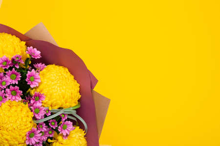 Lush and small chrysanthemums bouquet on bright yellow background with copy space, text place. Flower shop certificate. Holiday greeting card to Mother day, International Woman Day, Valentine Day.の写真素材