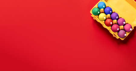 A package of chicken eggs with fluffy white tails like Easter bunnies painted in gray and yellow on a solid gray background with copy space, empty text place. Banner for the religion holiday. Mockup.の写真素材
