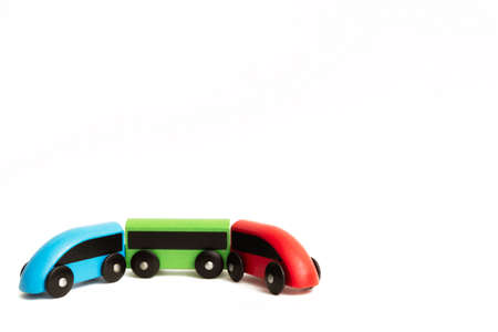 Toy wooden train isolated on white background with copy space text place. Red and blue locomotives, green wagon. Baby play transport. RGB color concept. Eco-friendly good shop. Banner. Transportation.の写真素材