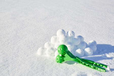 A children toy is a tool for modeling snowballs from snow. Green color plastic device. Winter outdoor kids games. Active leisure gift. Snowy background. Copy space. Banner. Ice forceps. New year time.の写真素材