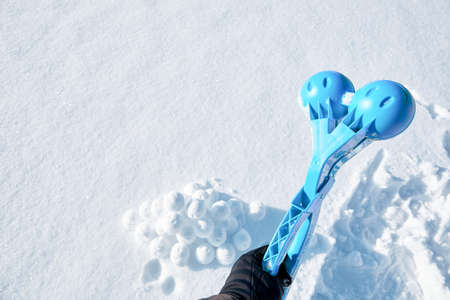 Children toy is a tool for modeling snowballs from snow. Blue color plastic device. Winter outdoor kids games. Active leisure gift. Snowy background. Copy space. Banner. Ice forceps. New year time.の写真素材