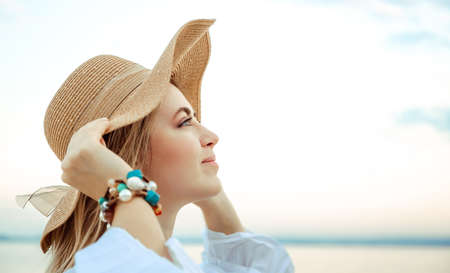 Portrait of beautiful young 30 years woman caucasian appearance in straw hat with satin ribbon bow....