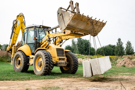 Wheel loader. Excavator install the foundation blocks into a trench. Retaining wall building....