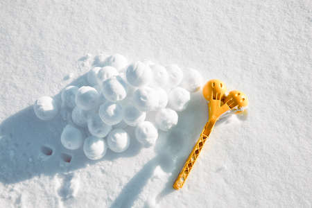 Children toy is a tool for modeling snowballs from snow. Yellow color plastic device. Winter outdoor kids games. Active leisure gift. Snowy background. Copy space. Banner. Ice forceps. New year time.の写真素材
