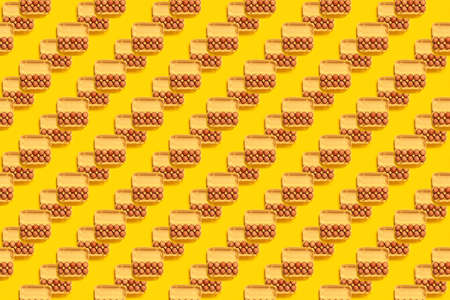 Seamless pattern. Natural organic chicken eggs in cardboard package isolated on yellow background, top view, copy space. Food banner. Business card of grocery store. Fresh eco farm product. Textureの写真素材