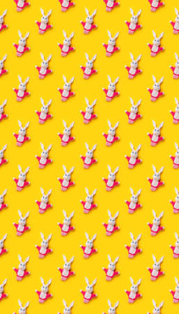 Seamless pattern. Easter bunnies isolated on yellow background. Funny texture. Education toy theater online course. Hand puppet. Sewing hobby. Fairy tale character. Fluffy baby play friend. Wallpaperの写真素材