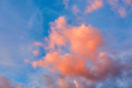 Purple, pink and orange tints clouds in the blue sky at sunset. Big fluffy cumulus cloud. scenic wallpaper. nature background. colorful space. evening cloudscape. peace concept. heaven paradise. Pure.の写真素材