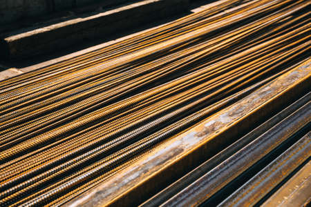 Metallic bars. Profile pipe and steel rods for the concrete reinforcing lies in the truck. Reinforcement bars delivery to the construction site. Strong metal building rebar close-up. copyspace. Rust.の写真素材