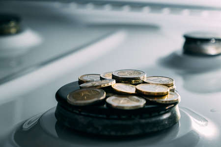 concept of gas crisis. 2 Euro lay coins on a kitchen stove burner when the gas end. High prices of...