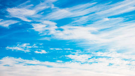 White spindrift clouds moving fast in light blue sky. cloudscape. nature background. Windy weather...