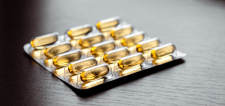 Yellow capsule blister lies on table background. Omega 3. Fish oil. Banner. close-up. side view....