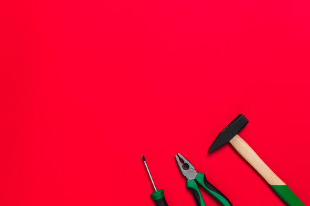 A set of quality green building tools to repair a car or a house on a red background. Do it yourself instruments. Banner for advertising construction shop with copy space. business card.の写真素材