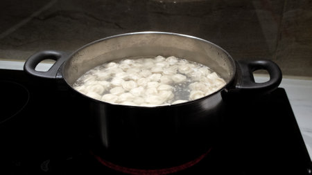 Small size meat dumplings are boiling in a pot on the stove. Pelmeni are the traditional national Russian cuisine. Italian ravioli. food for children. Dish for kid. Cooking lunch or dinner for family.の写真素材