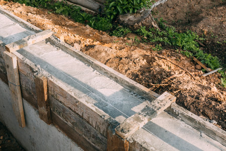 Timber formwork with metal reinforcement with pour concrete and creating a solid foundation for a building or fence. construction process. Building the retaining wall. side view. Nobody. copyspace.の写真素材