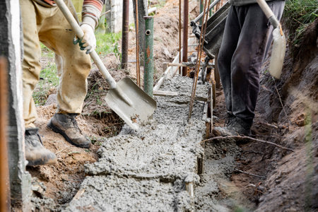 Timber formwork with metal reinforcement for pouring concrete and creating a solid foundation for a building or fence. construction process. Building the retaining wall. Shovel cement leveling. work.の写真素材