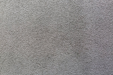 Sample of a texture of gray plaster. Wall finished with a decorative cement stucco. Example of exterior building decoration. Clean uniform grain background. Banner. wallpaper. copyspace. pattern.の写真素材