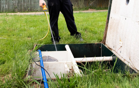 The man is cleaning septic. Maintenance autonomous sewerage service. Processing station biological water purification. local household sewerage system. environmental protection. water protection zone.の写真素材