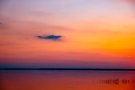 Beautiful orange sunset above the lake. Sky with clouds. Morning time. Seascape. Calmwater. natural background. nature landscape. summer time travel. warm evening concept. no people. Morning time.の写真素材