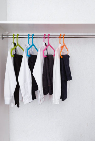 Boys school uniform on hanger. clothes for education. Classical style of black and white colors. Trousers and shirts in wardrobe. 1 September. Pupil style.の写真素材