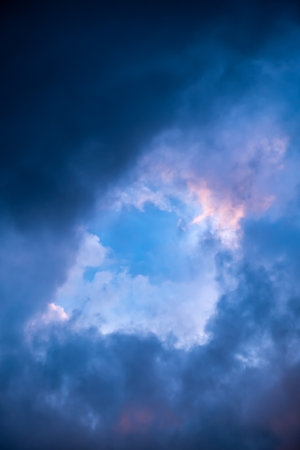 Blue hole in the dark cloudy sky. Storm Clouds. Evening sunset. Rainy and stormy weather. Art wallpaper Natural landscape. Beauty in nature. After thunderstorm. The hope concept. High quality photo.の写真素材